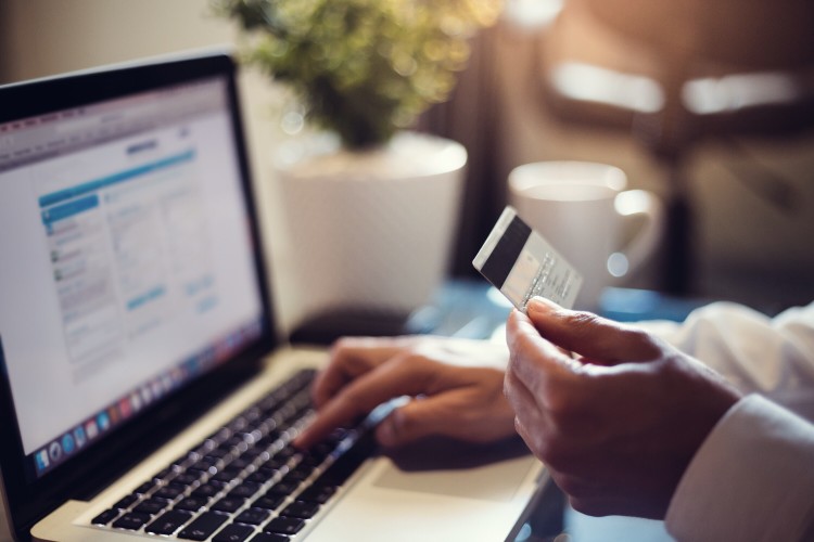 diferença entre extorsão e estelionato - pessoa segurando cartão de crédito